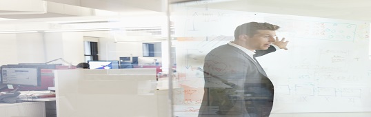 Businessman pointing to diagram on whiteboard in meeting